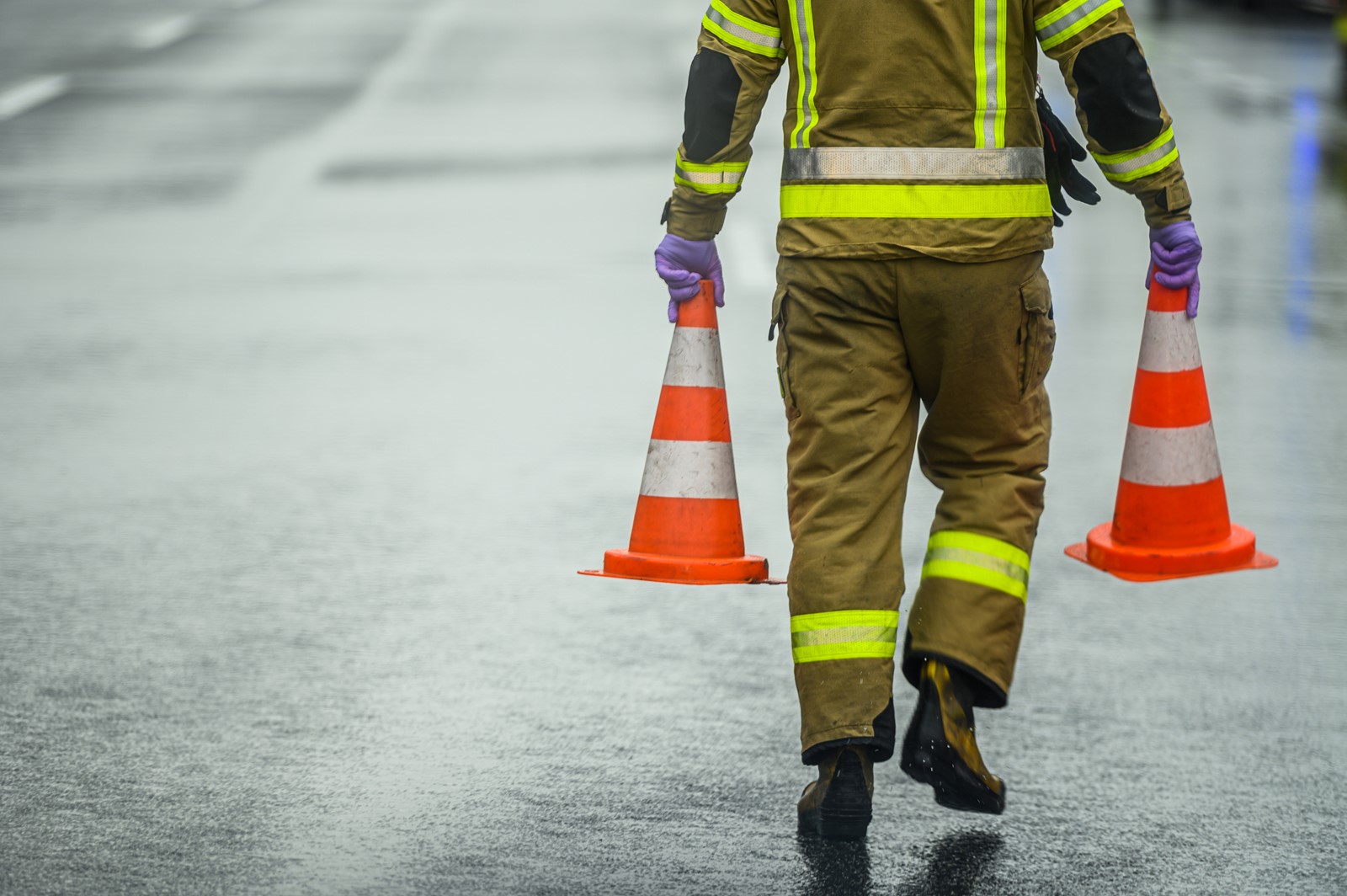 Highway Worker Preparing For Road Closure Moving Two Traffic Cones