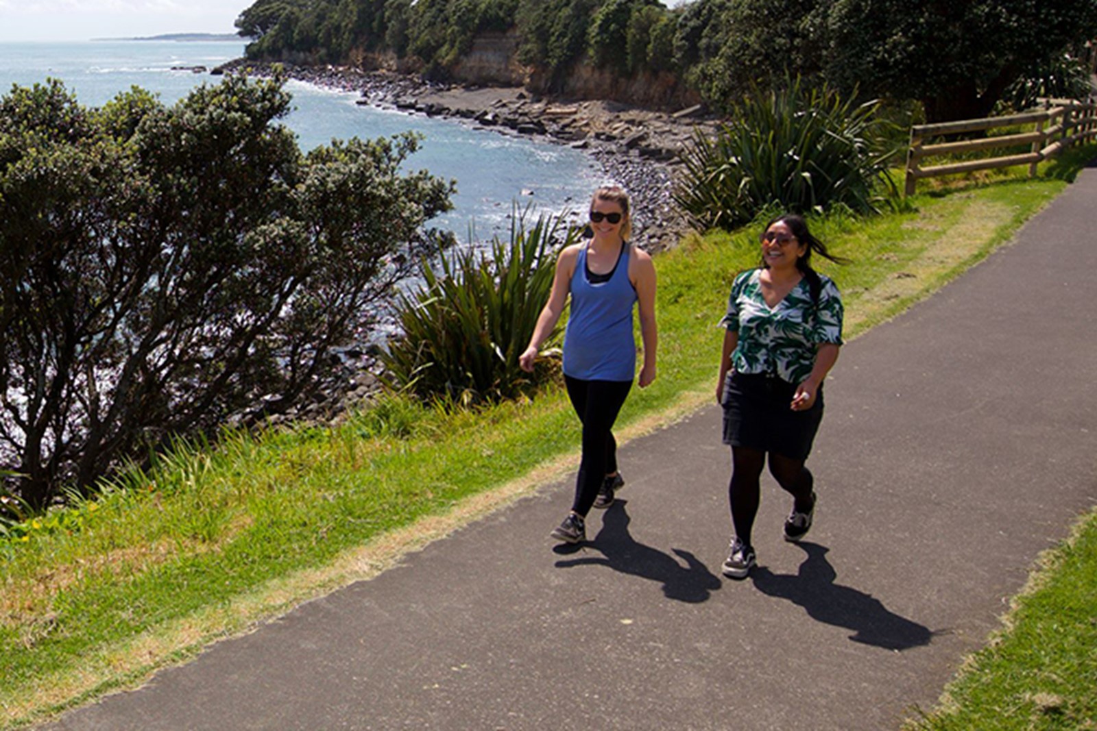Two women walking on the coastal walkway