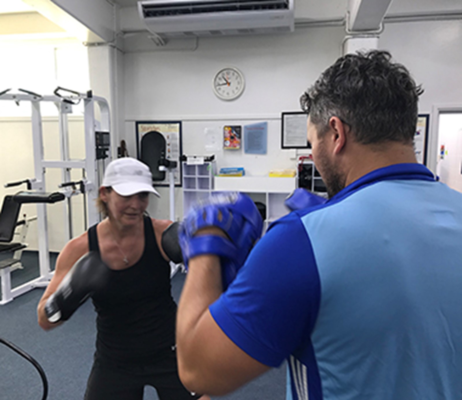 Trainer and woman boxing 