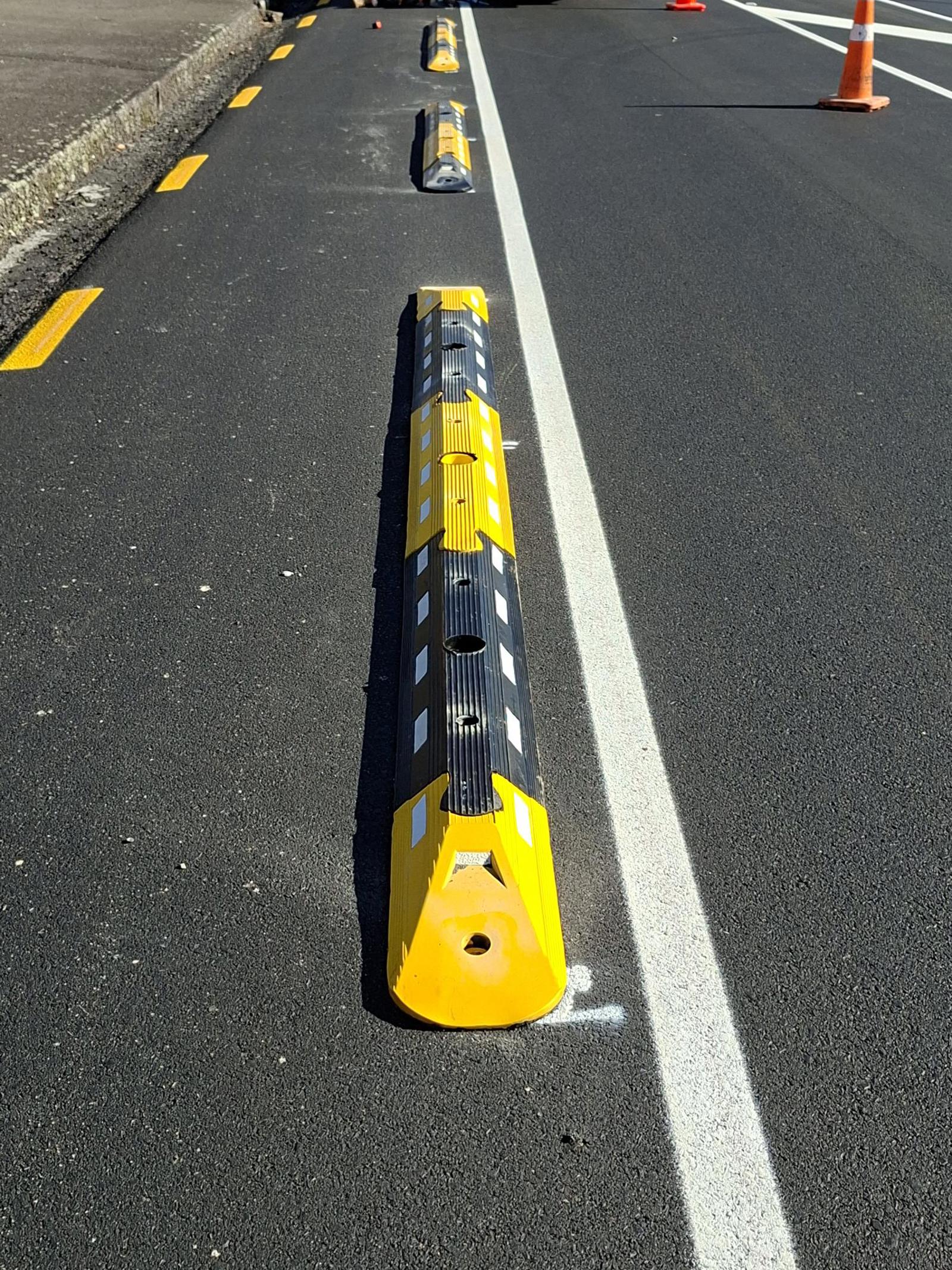 Black and yellow cycle separator on the road 