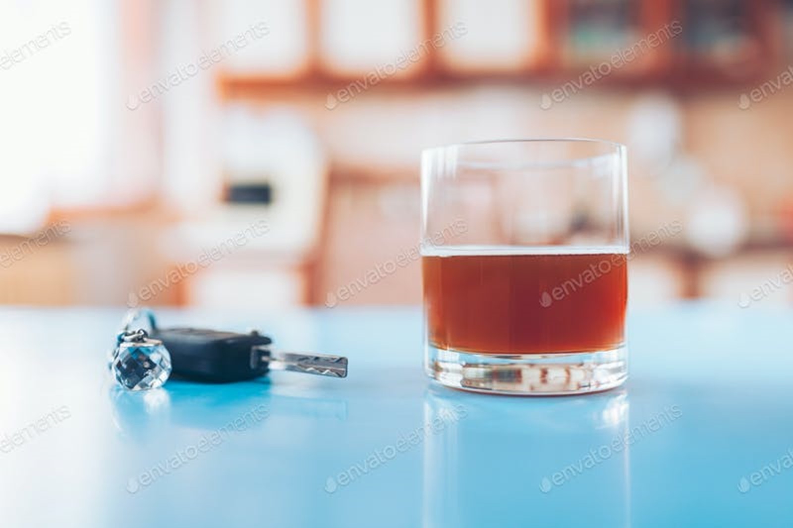 Drink driving. Car key and a glass of liquor