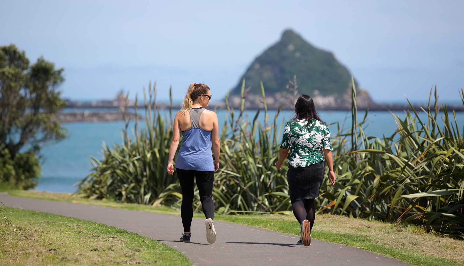 Two women walking on the coastal walkway